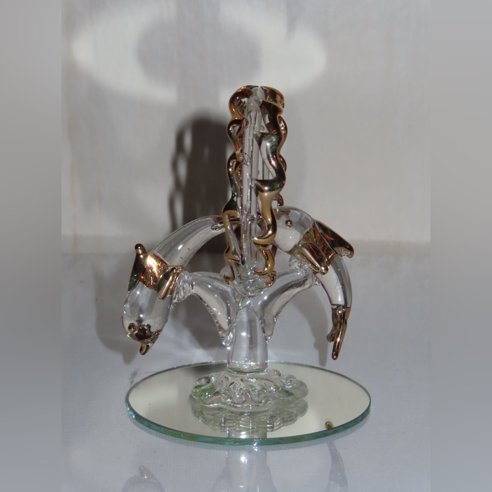 A pair of dolphins diving through a circle with a chrome/gold color lining